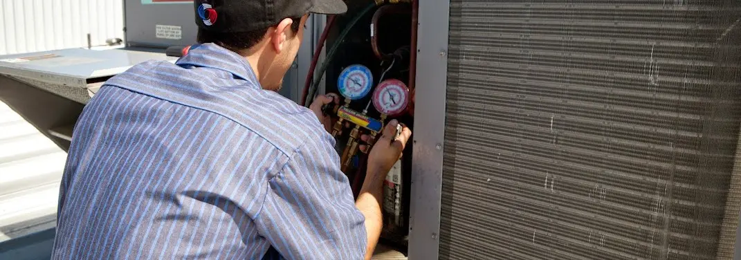 HVAC technician servicing a condenser unit in South Plainfield